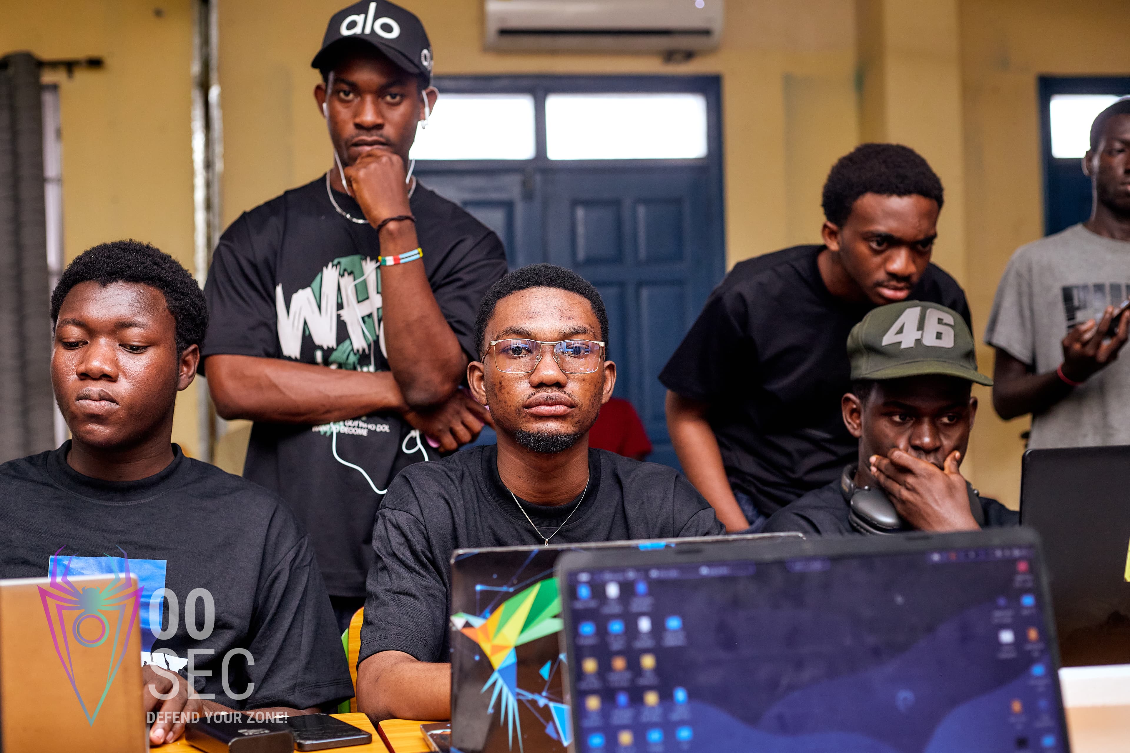 Students gathered around laptops at a campus cyber club activation.